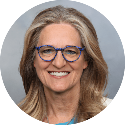 Porträtfoto einer lächelnden Frau mit langen blonden Haaren und blauer Brille