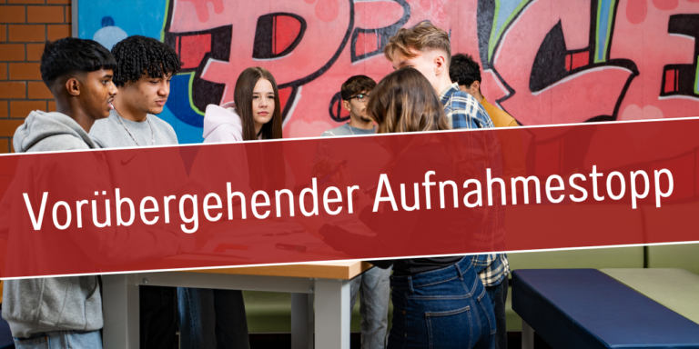 Gruppe Jugendlicher in einem Schulgebäude mit dem Hinweis: Vorübergehender Aufnahmestopp